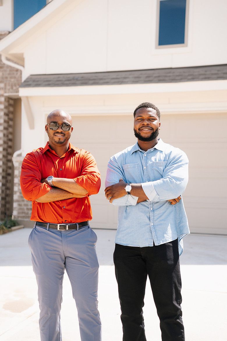 Henry and his client, arms crossed, outside the home